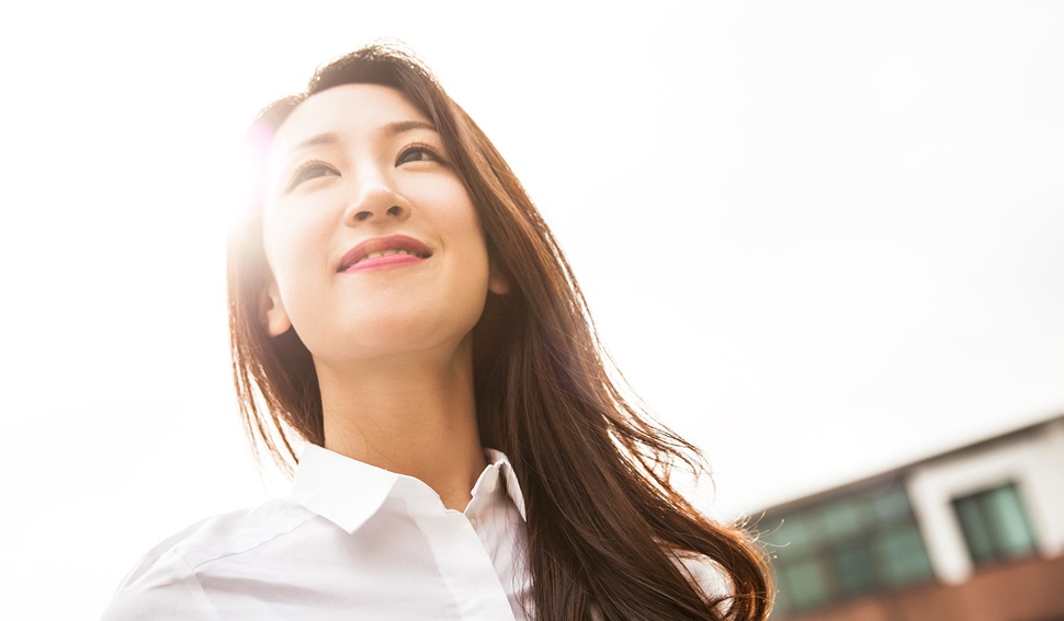 Female professional wearing a white shirt, smiling and looking positive