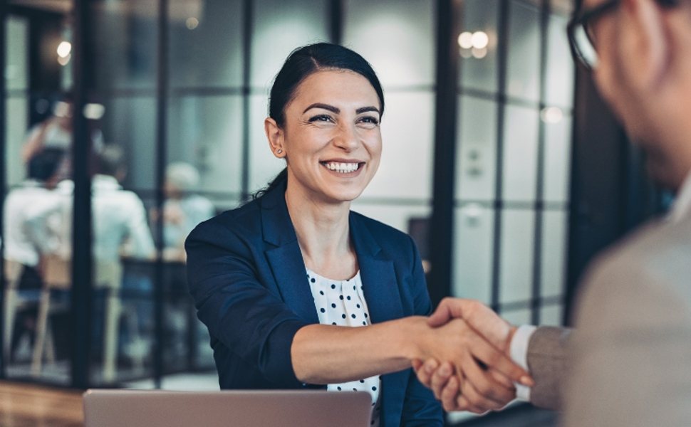 A female professional shaking hands with a recruiter.