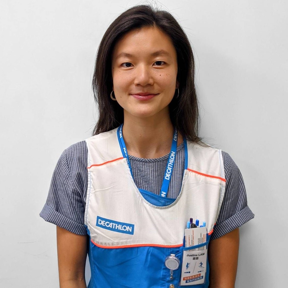 Person wearing a blue and white uniform with a name tag.