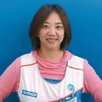 A smiling person wearing a sports vest.