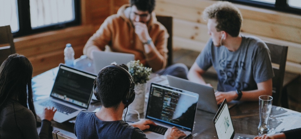 four people discussing over laptop
