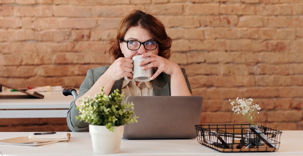 A female professional sipping on a mug while researching top recruitment agencies in Taiwan