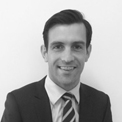 Person in a suit smiling at the camera.