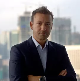 Person in a suit standing in front of a city skyline.