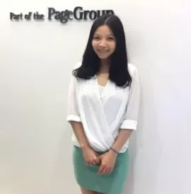 Person smiling in front of PageGroup sign