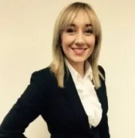 A person in a suit smiling at the camera.
