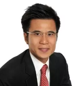 Person smiling in formal attire with glasses