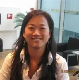 A person sitting in an office chair, smiling.