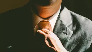 穿著西裝的人正在調整領帶。