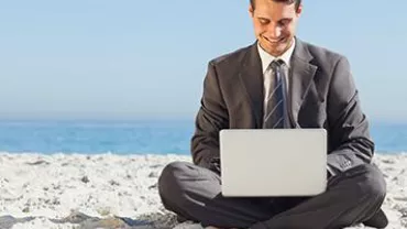 Person using a laptop on the beach