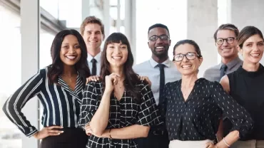 Group of smiling professionals in an office setting.