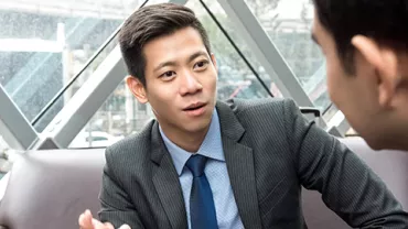 Two people having a conversation in an office.