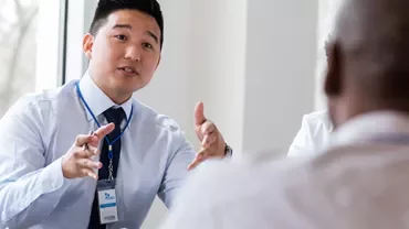 Individual speaking at a conference table.