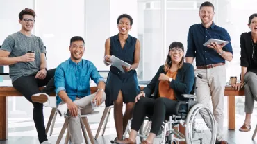 A group of people smiling together in an office.