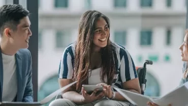 Three people having a discussion in an office