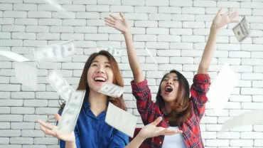 Two people enjoying throwing money in the air.