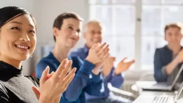 Group of people clapping in a meeting room