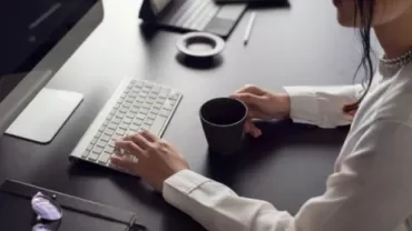 A professional preparing to write a farewell email to her colleagues before her departure.