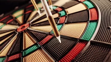 Close-up of darts embedded in a dartboard.