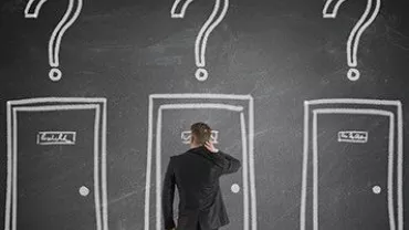 人在三扇標有問題的門前沉思