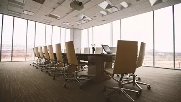 Large office meeting room with a long table and chairs.