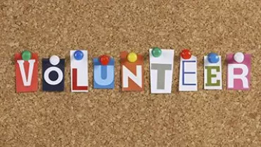 拼貼字母貼在軟木板上拼成“VOLUNTEER”