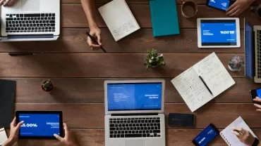 多人在辦公桌上使用筆記本電腦和平板電腦。