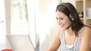 A person wearing headphones using a laptop.