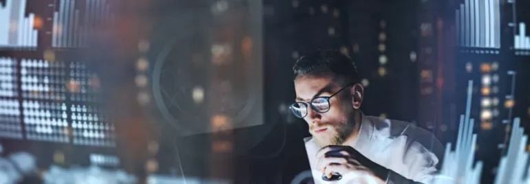 Person analyzing data charts on a computer at night