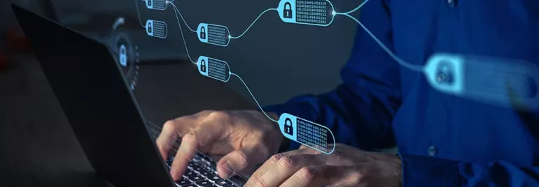 Hands typing on a laptop with blockchain icons visible.