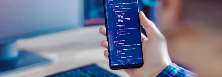 Person holding a smartphone displaying code.