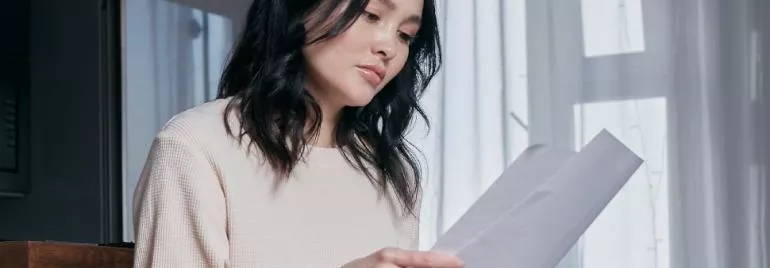 一個人在檢查文件，透過窗簾透進來的陽光。