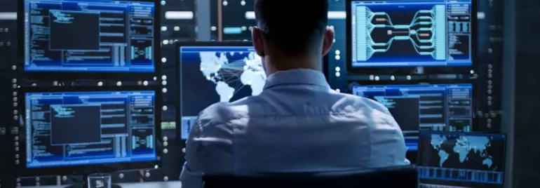 Person working with data on computer screens in a modern office
