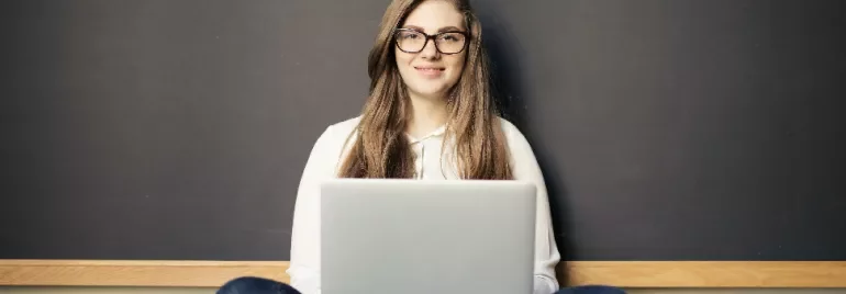 Woman-Smiling-While-Using-a-Laptop