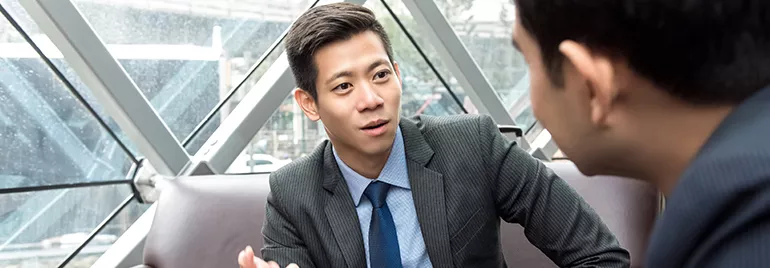 Two people having a conversation in an office.