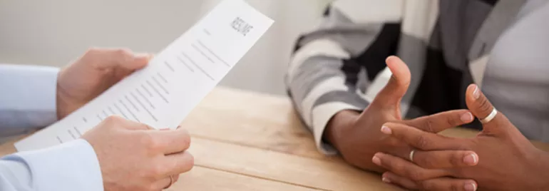 Close-up of a person holding a resume during an interview.