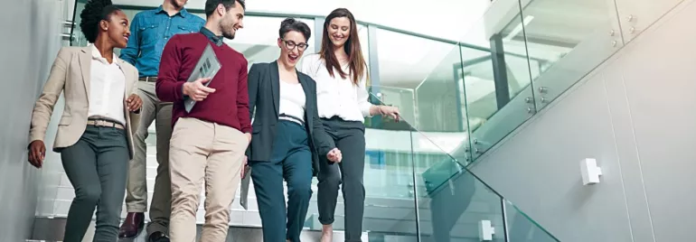 Colleagues walking and chatting on office stairs.