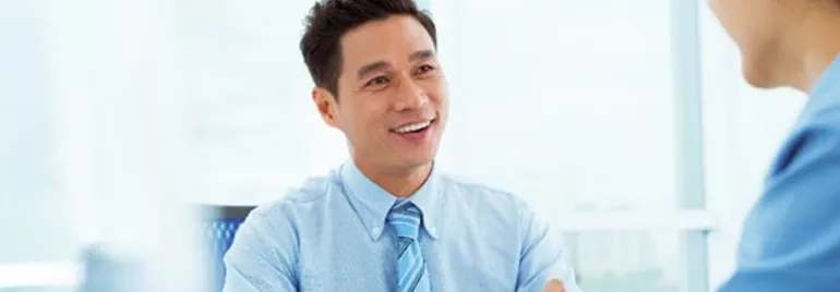 Two people having a conversation in a bright office.