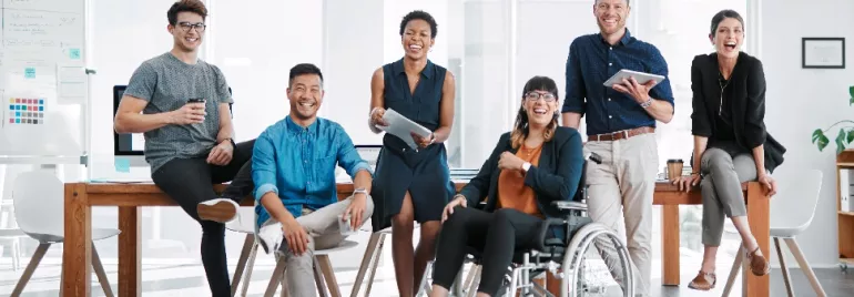 A group of people smiling together in an office.