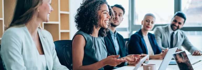 A group of people happily discussing in a meeting room.