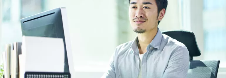 一位坐在桌子前，面帶微笑的專業人士。