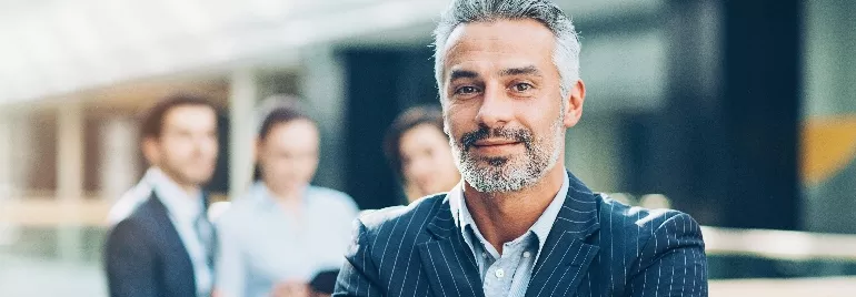 Person in a suit standing in front of blurred colleagues