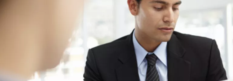 穿西裝的人在辦公室裡查看文件。