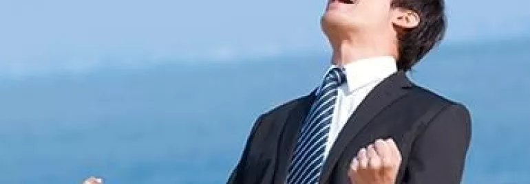一名身穿西裝的人在戶外，雙拳緊握，看上去非常高興。