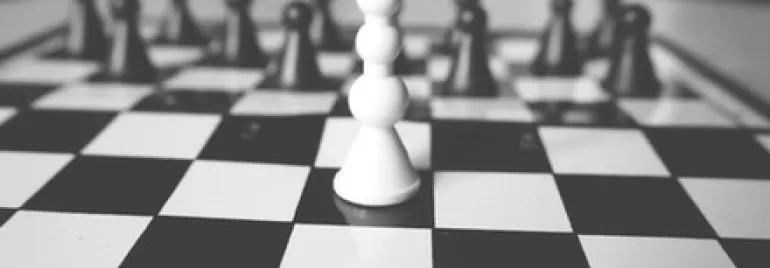 一個棋盤上的白色棋子，黑白對比強烈。