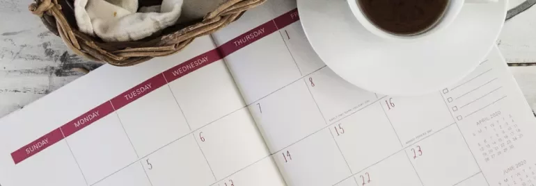 A cup of coffee and woven basket on a calendar.