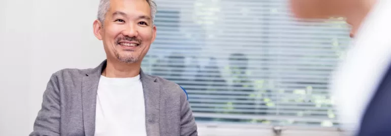 微笑的中年人在室內與他人交談