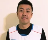 A person in a sports vest smiling at the camera