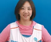 A smiling person wearing a sports vest.