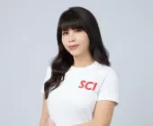 Person with black hair wearing a white T-shirt with red letters.